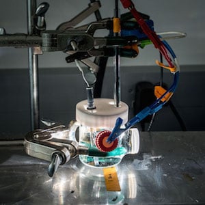 A bismuth vanadate thin-film electrode is tested in an electrolyte solution to mimic conditions in an artificial photosynthesis device. Image credit: Paul Mueller/Berkeley Lab.
