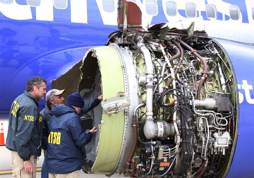 Investigators inspect the damaged engine. Source: NTSB