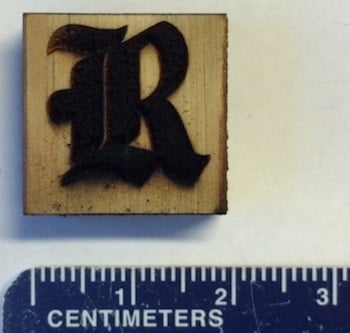 This Rice University athletics logo is made of laser-induced graphene on a block of pine.  (Courtesy of the Tour Group, Rice University)