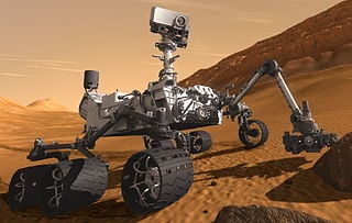 Artist’s concept of the Mars Curiosity rover extending its 2 meter-long arm. Image source: Wikimedia.