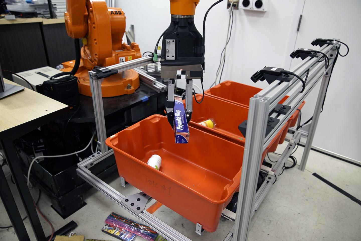 The 'pick-and-place' system consists of a standard industrial robotic arm that the researchers outfitted with a custom gripper and suction cup. Source: Melanie Gonick/MIT
