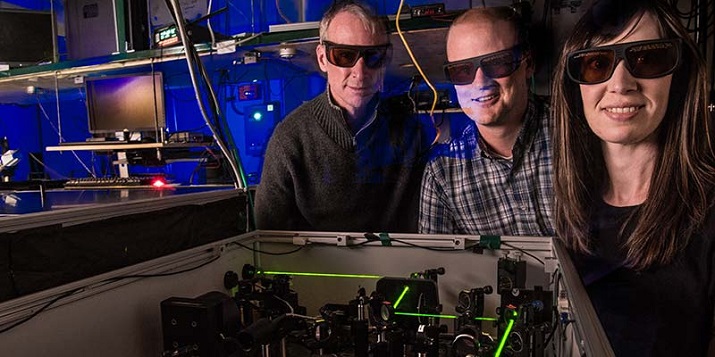 NREL researchers involved in the FBEB study, Paul King, David Mulder and Cara Lubner, stand next to a laser coupled with a spectrometer. Source: NREL