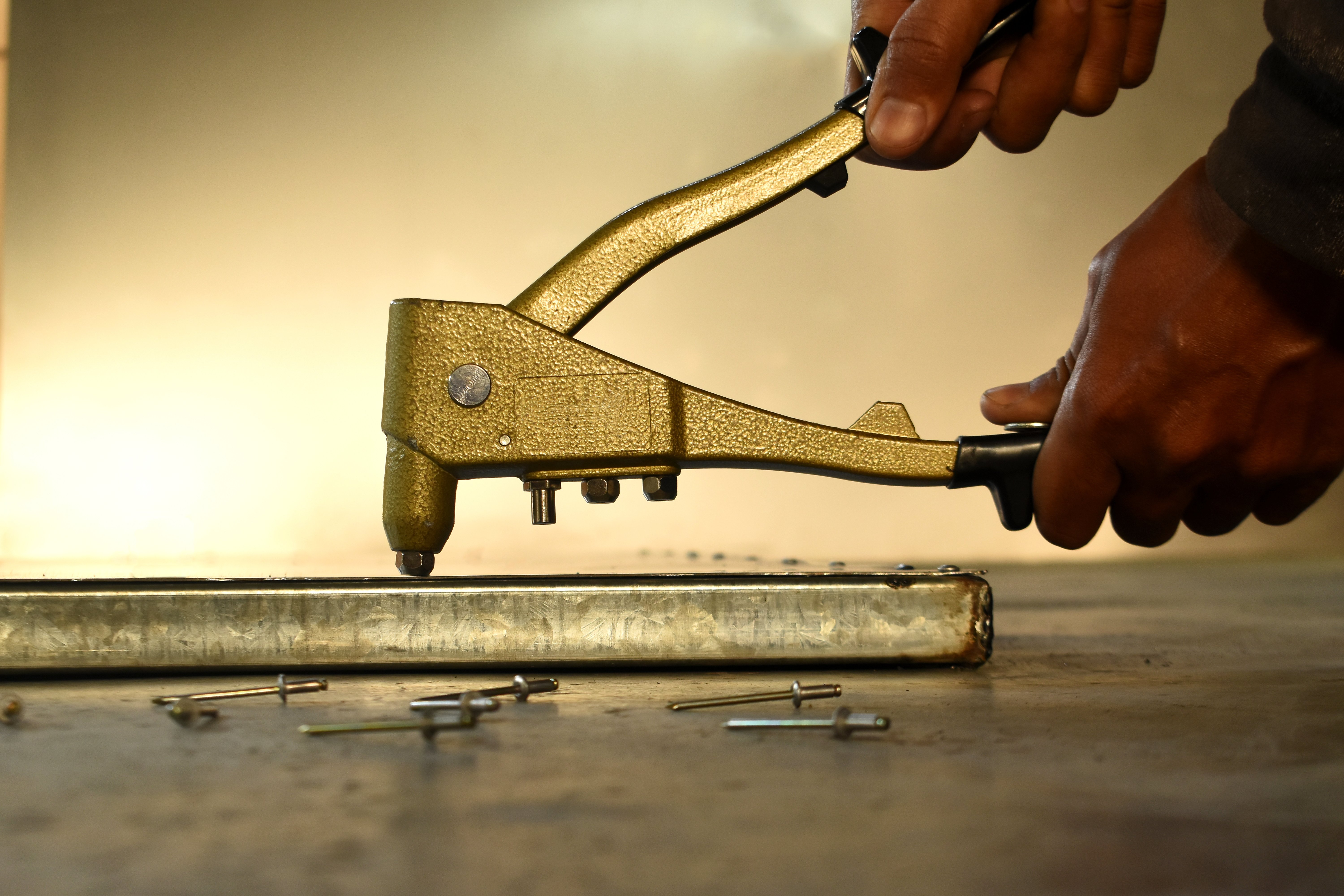 Hand rivet guns are sometimes used to install blind rivets. Source: Adobe/AfrandeePhotography