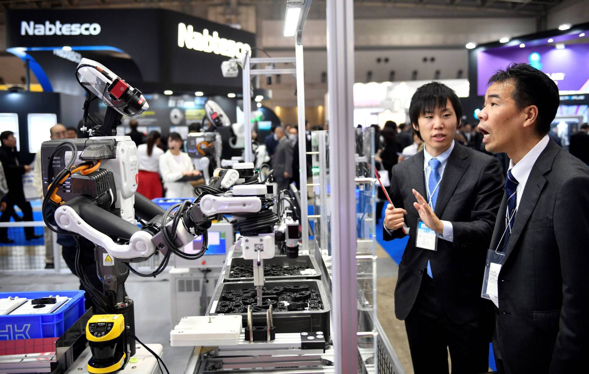 Attendees watch an industrial robot at a robotics fair in Tokyo. Source: EFE