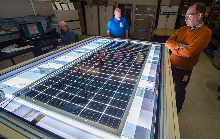 Allen Anderberg (left), Steve Rummel and Dean Levi of NREL's Cell and Module Performance group measure the power output of a PV module on NREL's solar simulator. Source: Dennis Schroeder, NREL