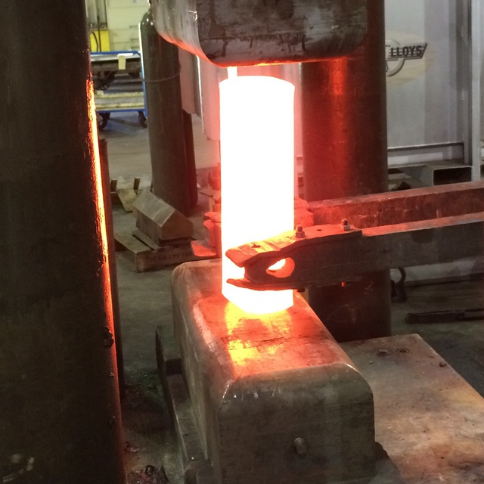Figure 1. Manipulator loading heated superalloy billet into open die forging press. Source: High Performance Alloys