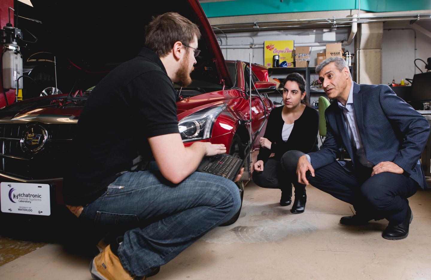 This is a photo of new valve technology that promises cheaper, greener engines, Amir Khajepour, a professor of mechanical and mechatronics engineering at Waterloo, in his lab working with his students (Source: University of Waterloo)