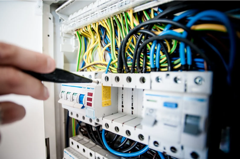 Figure 1: An electrician examines an open switchboard. Source: Pexels