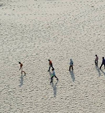 People walk on the dried Ganges riverbed during a drought in 2016. Source: NurPhoto SRL/Alamy