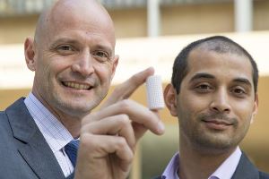J.R. DeShazo, left, and Gaurav Sant hold a sample of the building material created to replace concrete. Image source: Roberto Gudino/UCLA.