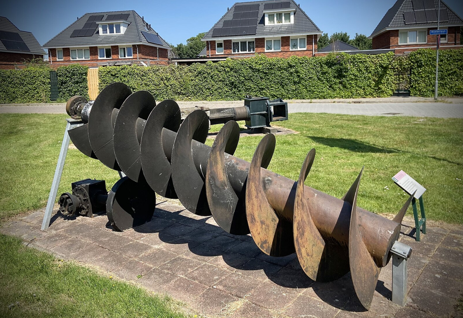 An Archimedes screw was one of the first screw feeders. It was used for moving water from lakes and rivers into ditches and troughs. Source: Kuroczynski/CC BY-SA 4.0 DEED