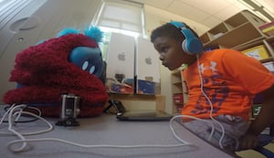 A child plays an interactive language-learning game with Tega, a socially assistive robot. Image credit: Personal Robots Group/MIT Media Lab.