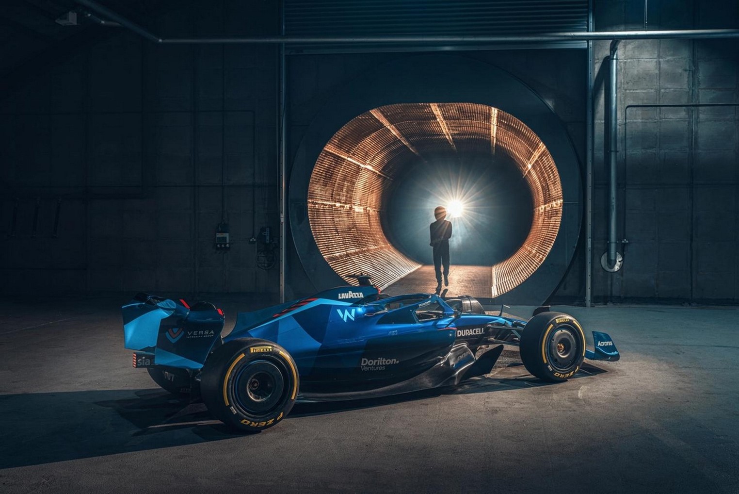 A person standing next to a race car in a garage  Description automatically generated with medium confidence Figure 1. In F1 racing, certain parts are especially well suited to customization with 3D printing. Source: Williams F1
