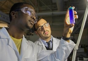 Researchers Will Smith and John Vericella look at microcapsules that can be used to capture carbon dioxide from coal or natural gas-fired power plants, as well as in industrial processes like steel and cement production. Photo by Julie Russell/LLNL.