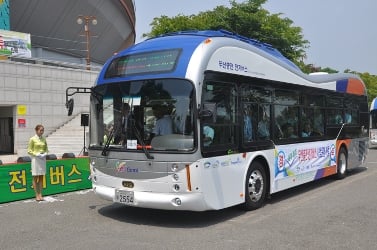 Two buses are equipped to recharge while driving over this roadway; the OLEV buses have coils on their underside to pick up power through the electromagnetic field on the road.