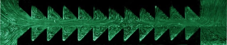 Squeezing and expanding a fluid repeatedly between two sawtooth-like boundaries generates a net flow to the right. Credit: AIP.org