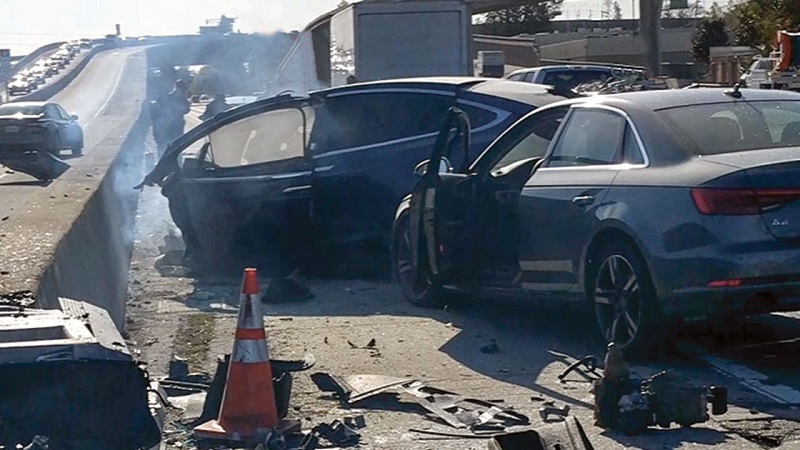 The fatal accident vehicle and one of two vehicles involved in the March 2018 accident. Seconds before the accident, the Tesla steered into the gore area of an exit off-ramp, apparently confused by indistinct lane markings and bright sunshine. An accident barrier, visible at the lower left of the photo, had been damaged days before the accident and contributed to the severity of the Tesla accident. Source: NTSB