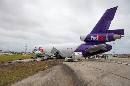 (Click to enlarge.) Photo showing the left side of the plane, including the collapsed landing gear. Source: NTSB