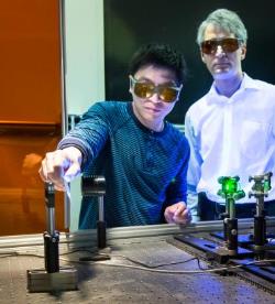 Jian Chen (left) and Adrian Sabau (right) use a laser to prep carbon fiber composite and aluminum for bonding. Credit: Oak Ridge National Laboratory