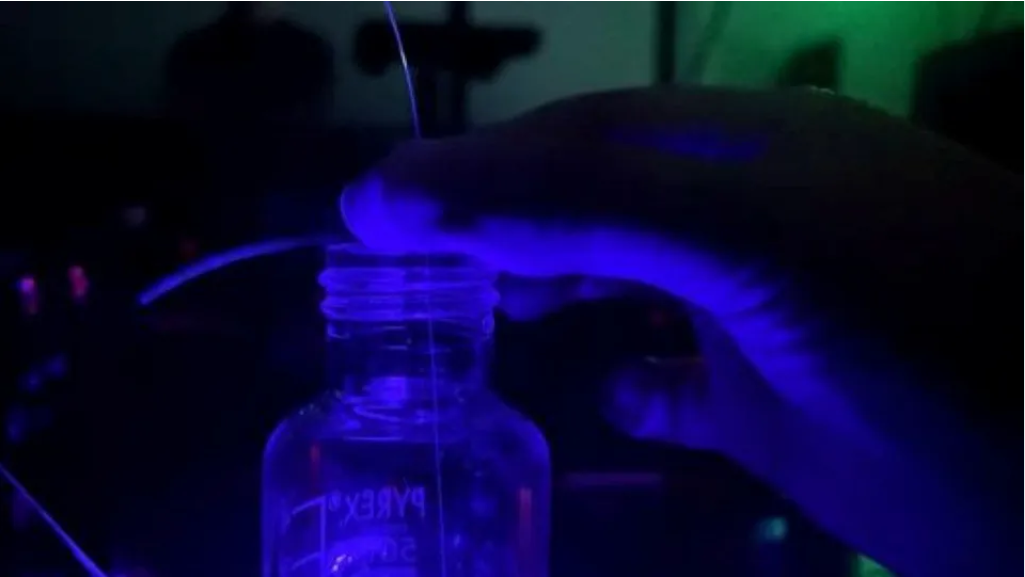 A fiber-optic probe with 3D micro-printed sensing structures is immersed in a liquid sample, where light-induced emission reveals changes in the chemical environment in real time. Source: Adelaide University