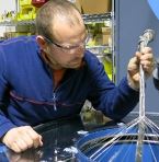 Chad Reams uses a braiding machine to put the final layer of shielding on a cable assembly. Credit: Natasia Kenosky/Letterkenny Munitions Center.
