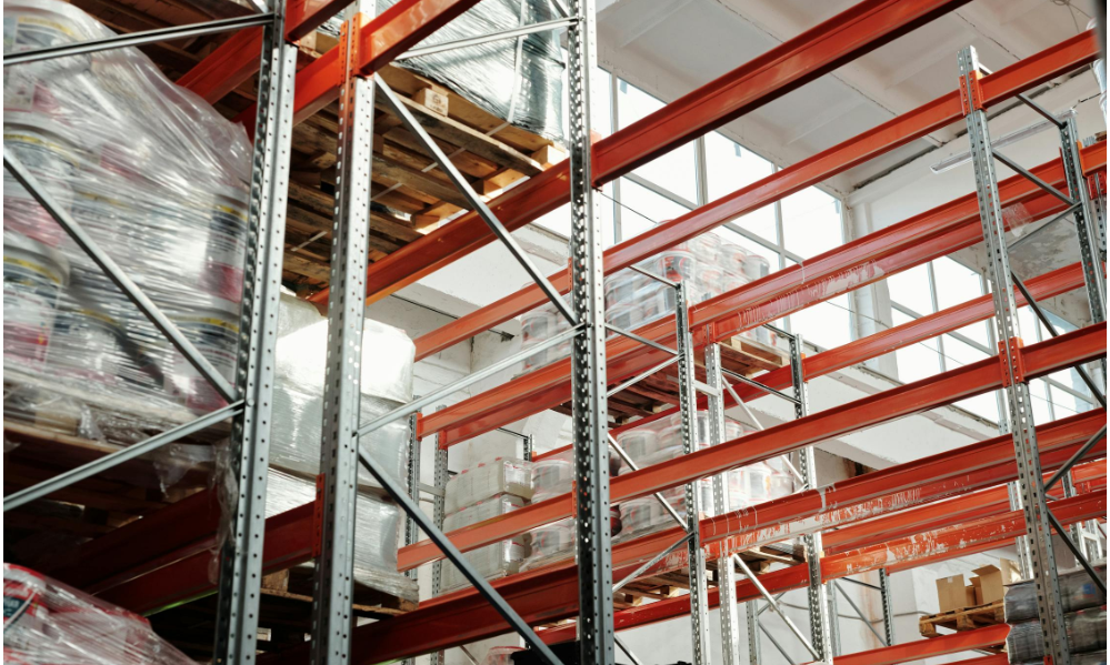 Stacked pallets and metal racking in a warehouse. Source: Tiger Lily/Pexels