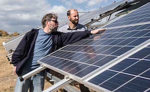 NREL engineers Bill Sekulic (l) and Chris Deline examine a new PV array outside NREL's headquarters building in Colorado. Image credit: Dennis Schroeder.