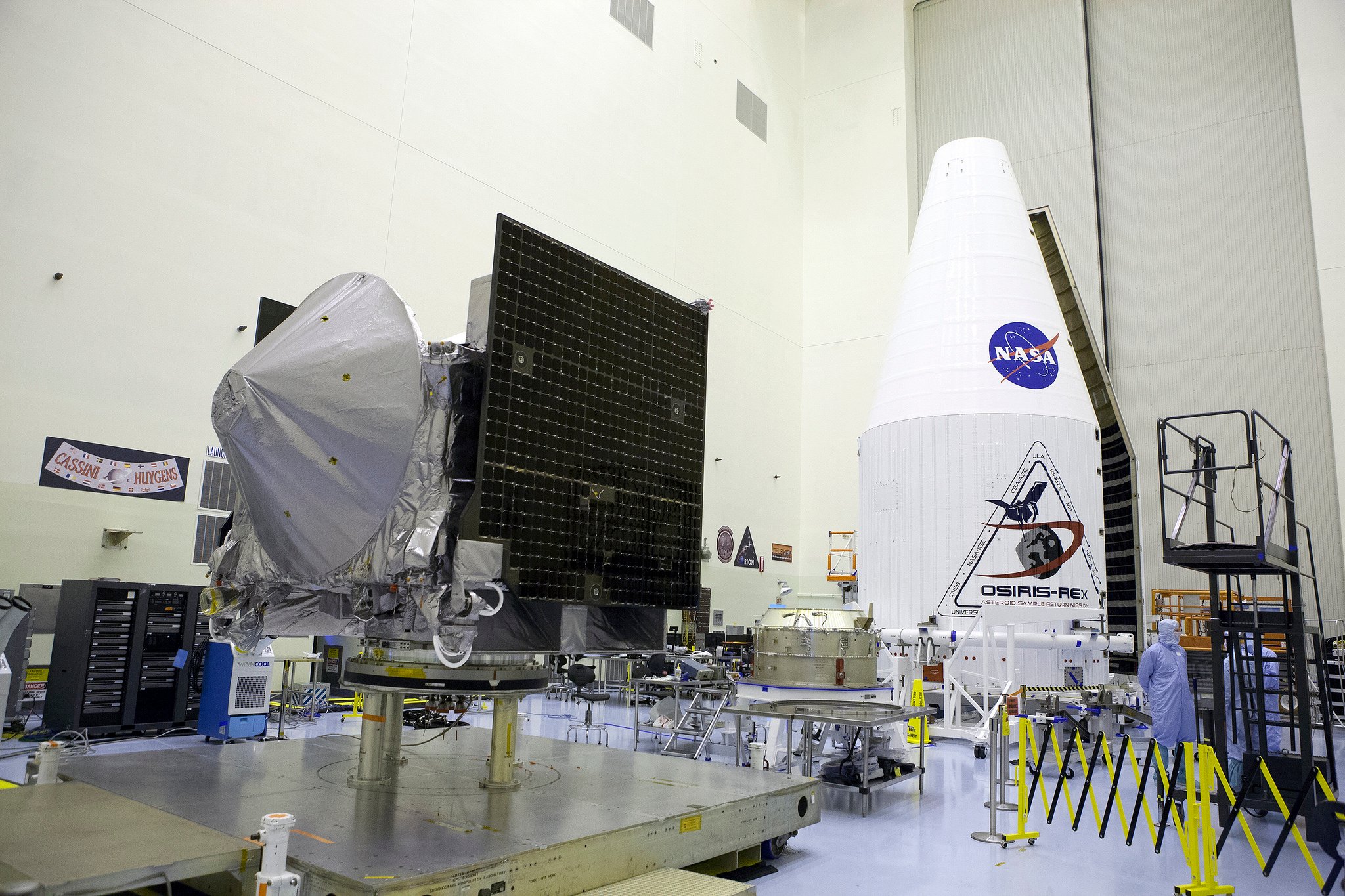 OSIRIS-REx sits on the floor of the Payload Hazardous Servicing Facility at NASA’s Kennedy Space Center next to the payload fairing that will protect it during its launch atop an Atlas V rocket. Source: NASA/Glenn Benson