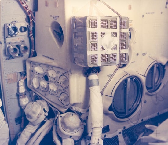 An interior view of the Apollo 13 Lunar Module and the jury-rigged carbon dioxide removal system, which the Apollo 13 astronauts built in order to use the Command Module lithium hydroxide canisters to purge carbon dioxide from the Lunar Module. This arrangement was rigged using the canisters from the Command Module. Credit: NASA