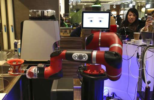 A robot barista named "Sawyer" makes a coffee at Henna Café in Tokyo on  Friday, Feb. 2, 2018. The cafe's robot barista brews and serves coffee as the rapidly aging country seeks to adapt to shrinking workforce.  Source: AP Photo/Koji Sasahara
