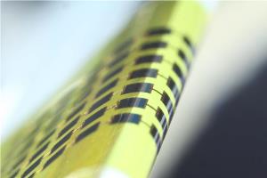 Ultra-thin solar cells are flexible enough to bend around small objects such as a 1mm-thick edge of a glass slide, as shown here. Source: Juho Kim, et al/ Applied Physics Letters 