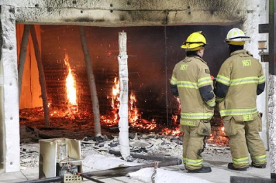 NIST firefighters survey the end of a controlled test to study the impact of fire on cross-laminated timber buildings. Source: NIST