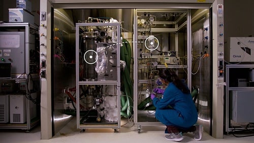On the left of this walk-in fume hood, "smoke" moves through a cylindrical container where it makes contact with a carbon-capturing solvent. That solvent chemically binds to carbon dioxide and, on the right, is converted to methanol. Source: Eric Francavilla/U.S. Pacific Northwest National Laboratory