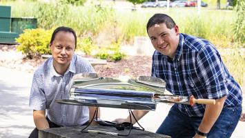 Radu Custelcean (left) and Neil Williams of ORNL used a solar-powered oven to generate mild temperatures that liberate carbon dioxide trapped in guanidine carbonate crystals. Source: Carlos Jones, ORNL, U.S. Department of Energy