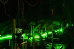 A system to monitor radiation damage in a material creates acoustic oscillations by using two pulsed laser beams.
