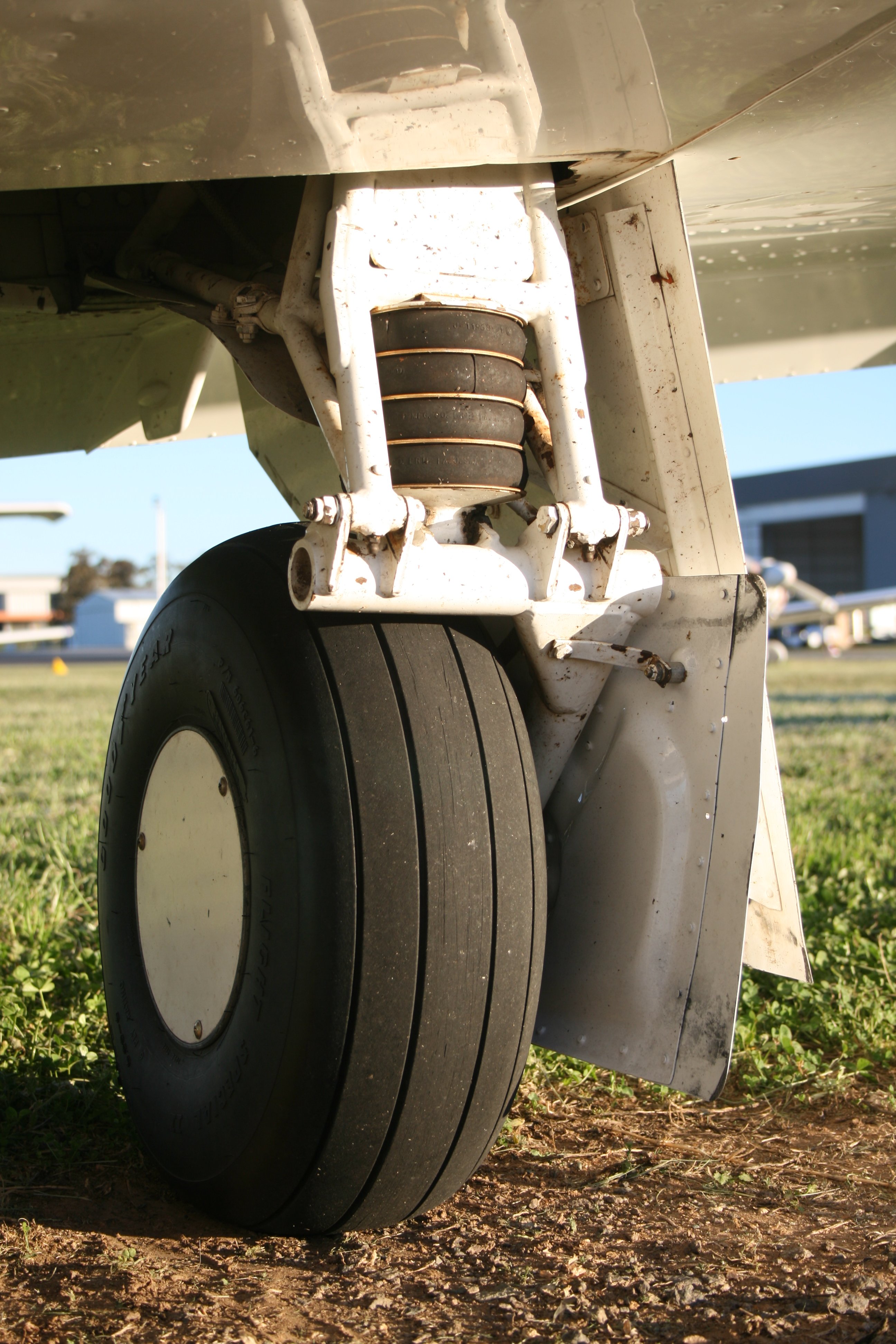 Rubber disc shock absorbers are seen in one of the two main landing gear legs of a Mooney M20F Executive 21, a single engine piston aircraft that seats a pilot and up to 3 passengers.