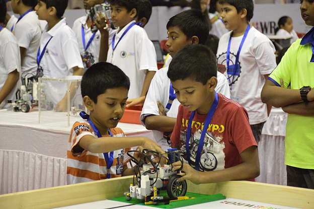 Young students calibrating a robot for a robotics competition. Source: Biswarup Ganguly/Wikipedia Commons